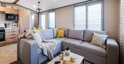 Cosy lounge with L-shaped sofa next to open-plan kitchen diner