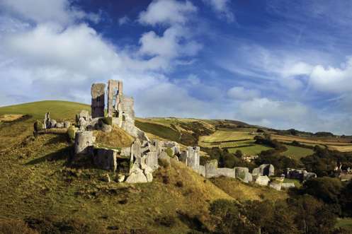 The ruins of a castle perched atop a hill among the Purbeck Hills