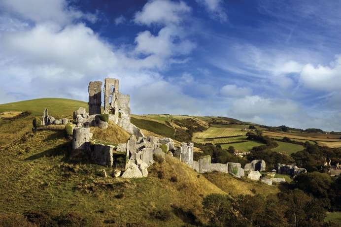 The ruins of a castle perched atop a hill among the Purbeck Hills