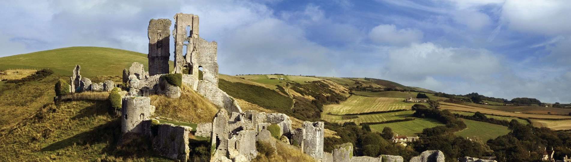 The ruins of a castle perched atop a hill among the Purbeck Hills