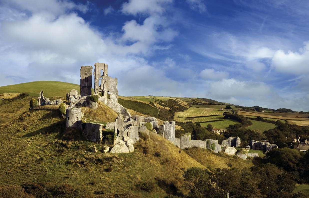 The ruins of a castle perched atop a hill among the Purbeck Hills