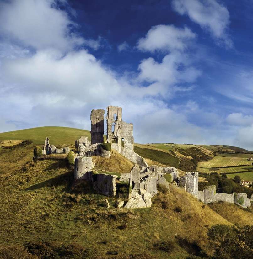The ruins of a castle perched atop a hill among the Purbeck Hills