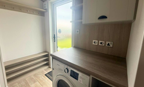 Internal of a caravan entranceway with washing machine and storage