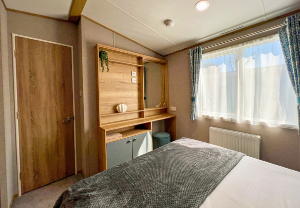Internal of a caravan master bedroom with dressing table