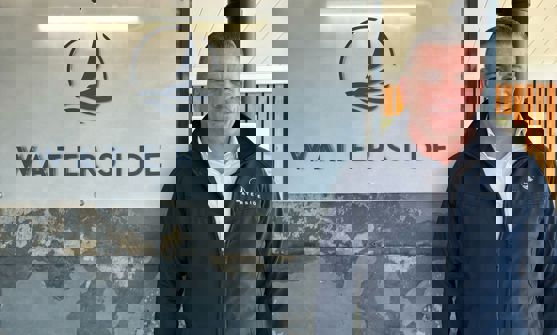 A smiling man stood beside a Waterside sign
