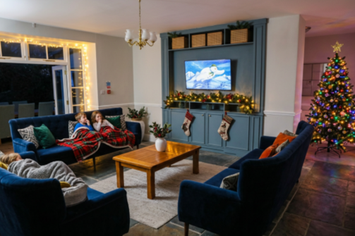 The open lounge at the Manor House decorated for Christmas with children curled up on the sofas watching The Snowman