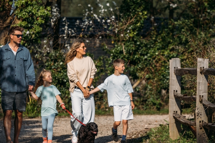Family walking dog on park