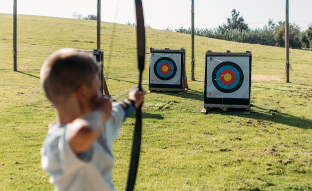 A Young Boy Playing Archery in the Countryside