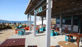 An outdoor beach bar and street food shack with outdoor seating by the sea