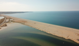 Aerial view of a stretch of Chesil Beach looking out towards the sea and Portland