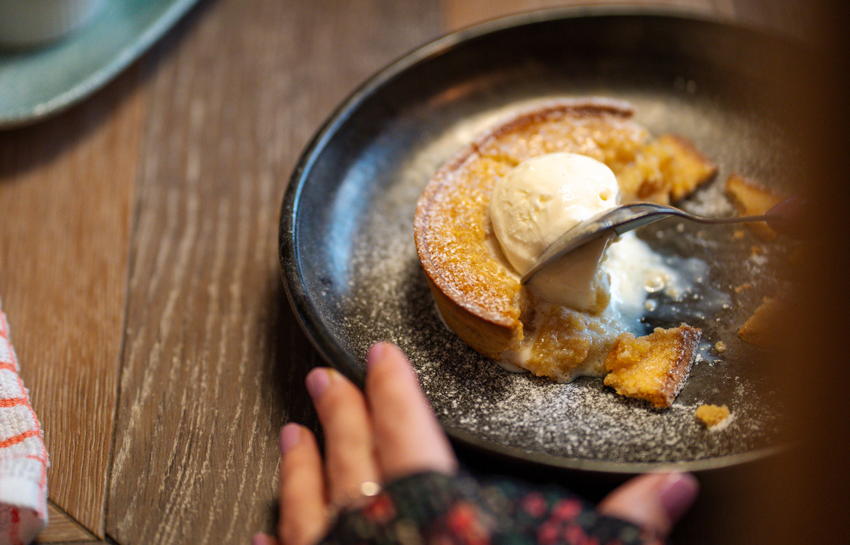 A pastry dessert with ice cream being cut with a spoon