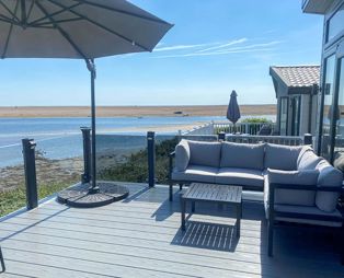 External of a caravan decking with outdoor furniture and seaviews