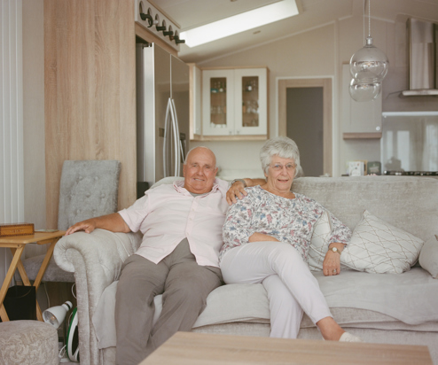 An older couple sat together on a sofa in a holiday home