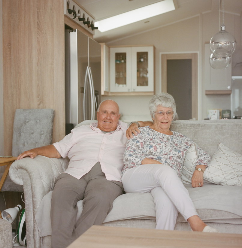 An older couple sat together on a sofa in a holiday home