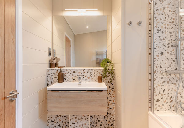 Internal of a luxury lodge bathroom with sink and shower over bath