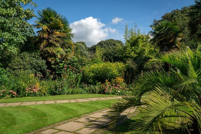A lush gardens of greenery and flowers with blue sky