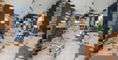 Modern lounge with comfy sofas, fireplace, natural wood, faux brick walls and dark blue walls design