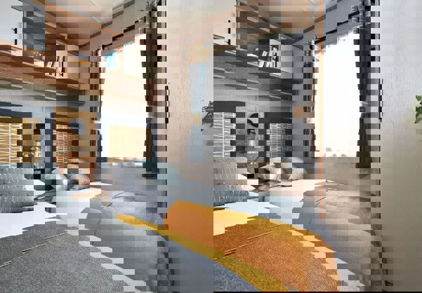 Twin room with cosy bedding, compact self-contained wardrobe, and shelving above the bed