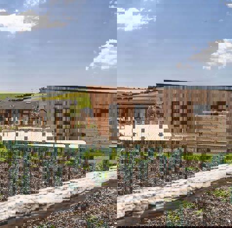 Exterior of a Super Lodge surrounded by Wildflowers and Rolling Hills