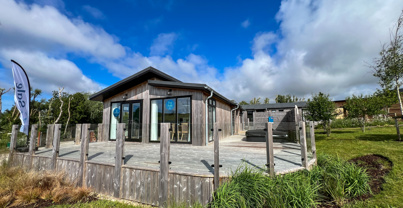 External of a luxury lodge on pitch with decking and hot tub