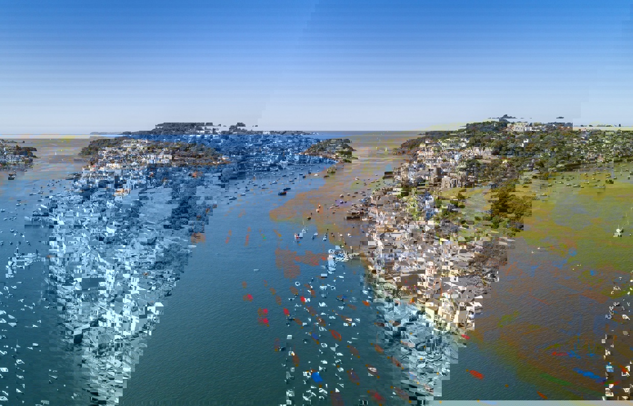 Fowey town and harbour from above with blue waters out to sea