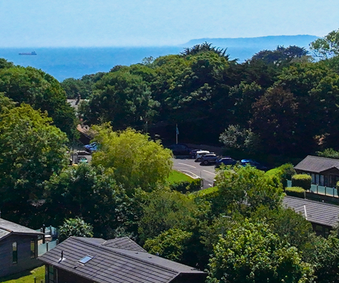 Osmington Mills Lodge Park from above with views of the sea and Portland in the distance