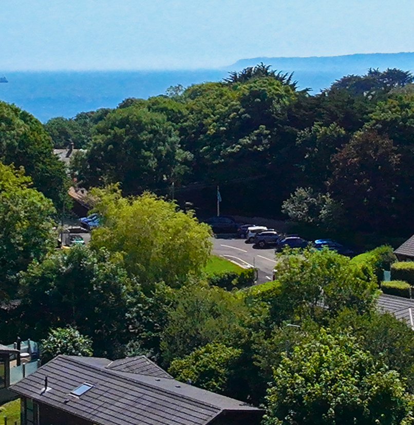 Osmington Mills Lodge Park from above with views of the sea and Portland in the distance