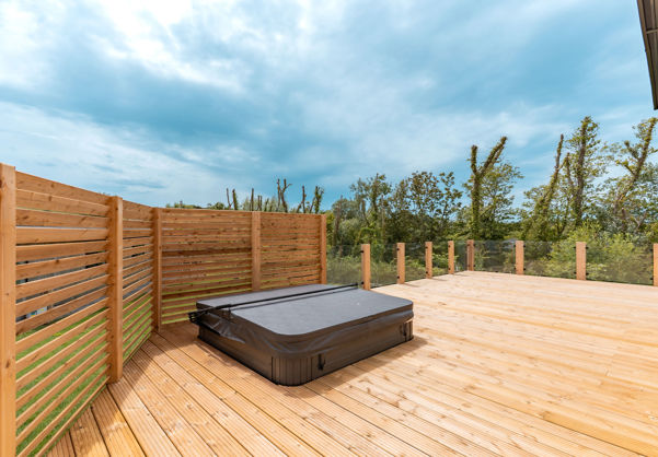 External of a luxury lodge with decking and hot tub