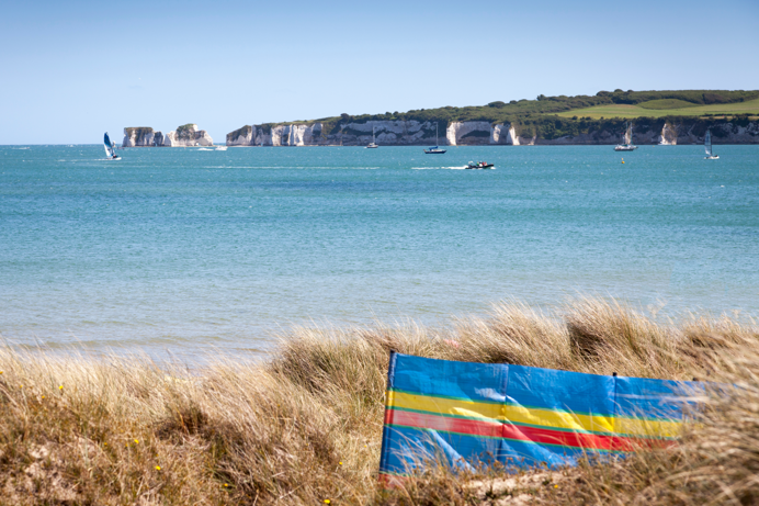 A coastal scene with boats in the sea and rocky cliffs in the distance