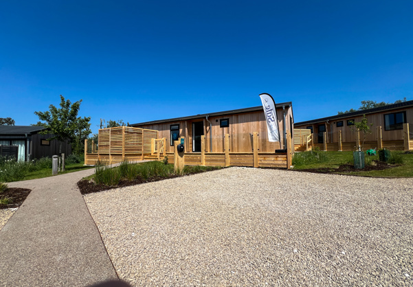 External of a luxury lodge on pitch with decking and designated parking space