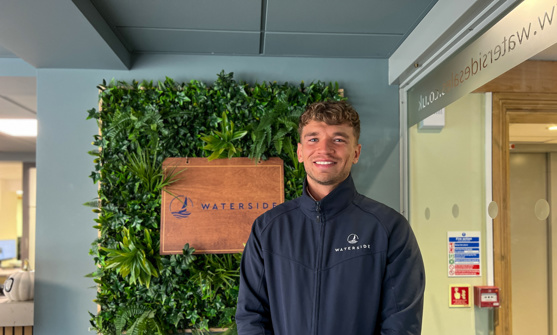 A smiling man stood beside a Waterside sign