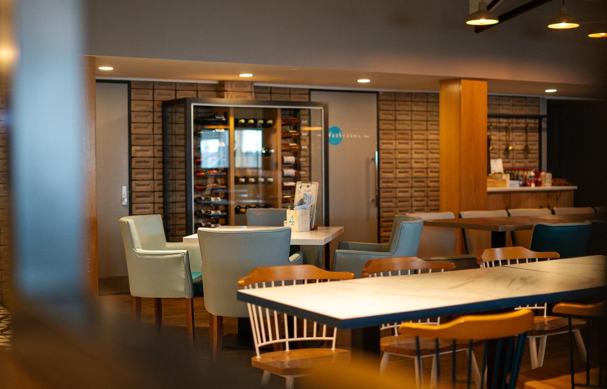 The internal of Breeze Bar & Grill with tables and chairs and a wine rack
