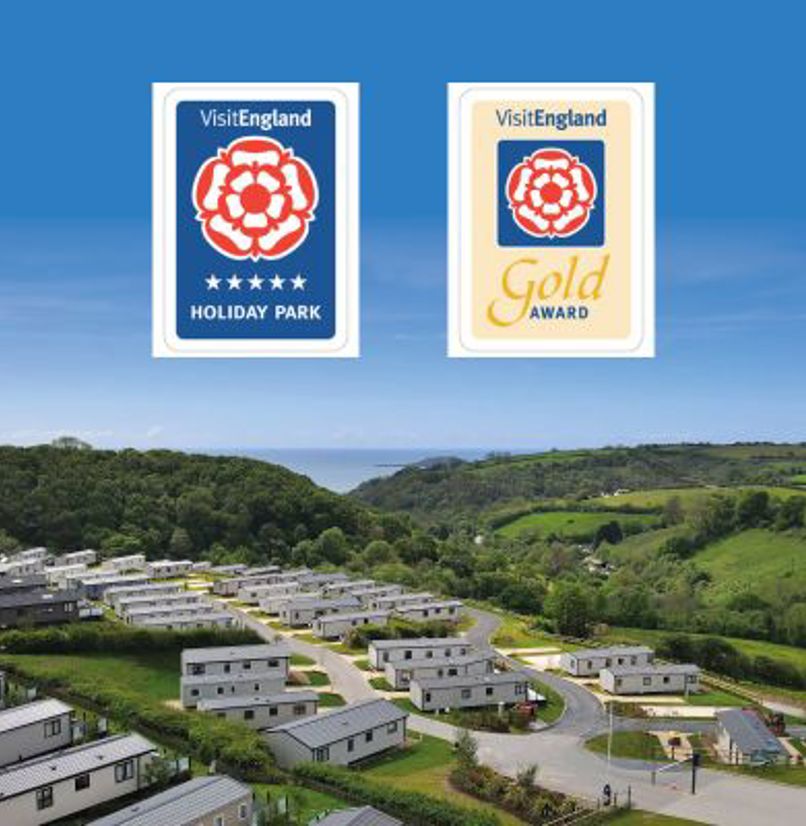 Drone view of Tregoad Holiday Park on a blue sky day with Visit England award graphics overlaid
