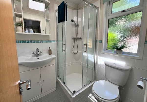 Internal of a lodge bathroom with shower, sink and toilet