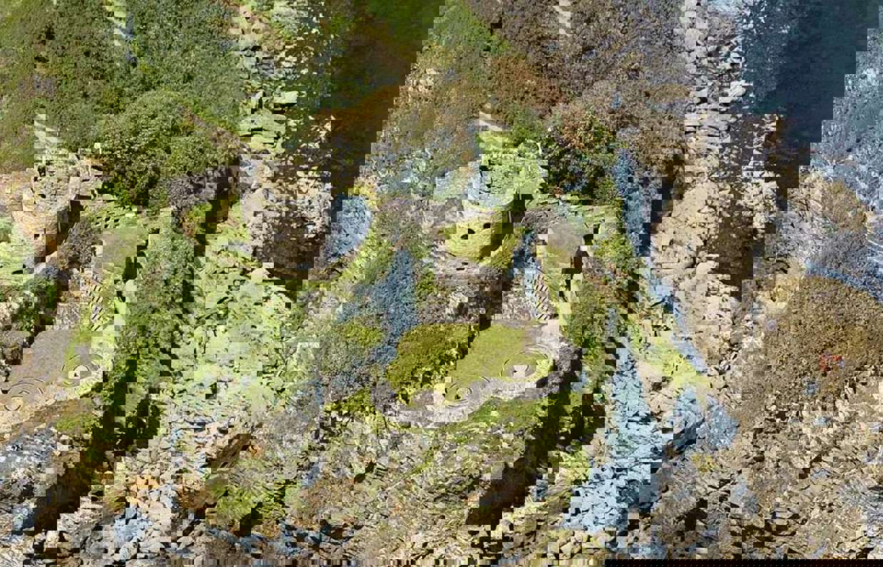 Aerial shot of St Catherine's Castle on the coast with blue waters