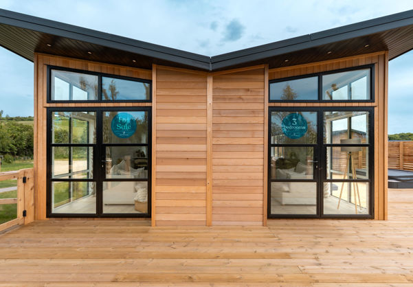 External of a luxury lodge on pitch with an inverted angel wing roof
