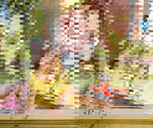 A toddler playing outside in a garden