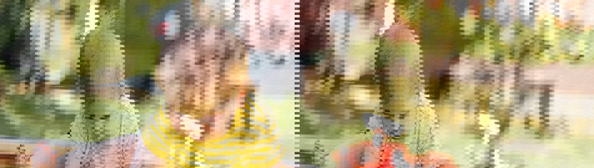 A toddler playing outside in a garden