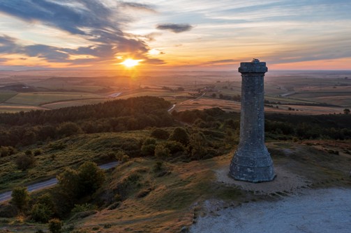 Hardy's monument atop a hillside with rolling countryside views at sunset