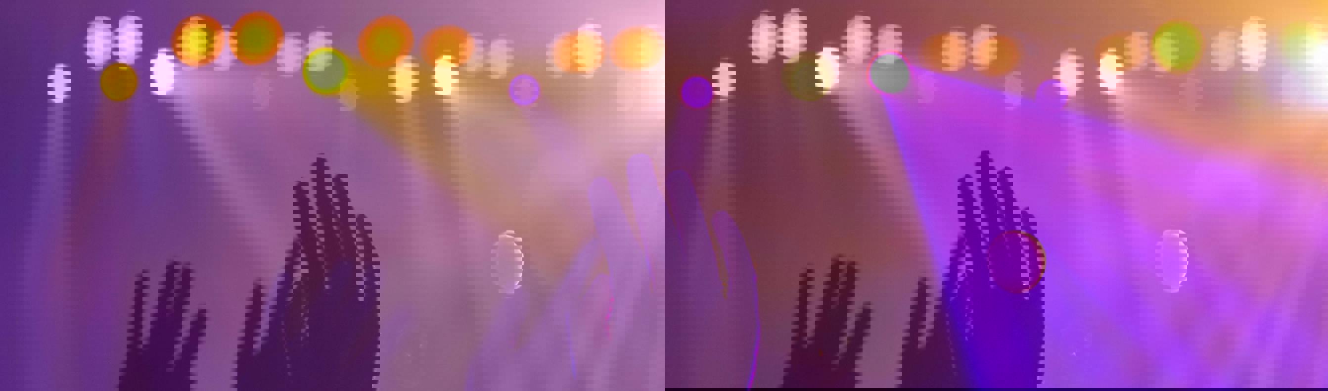 Arms raised at a performance with purple lighting and smoky atmosphere