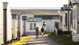 Couple walking down lane between caravans