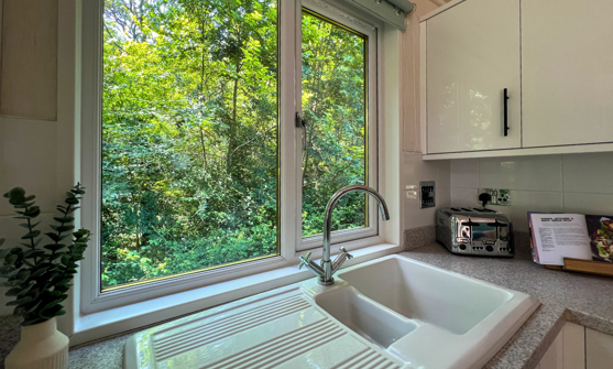 Internal of a lodge kitchen sink with views out to woodland 