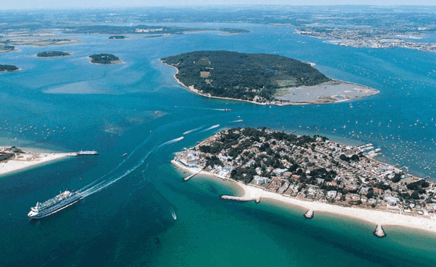 An aerial view of the coast with various islands and boats scattered in the striking blue water on a sunny day