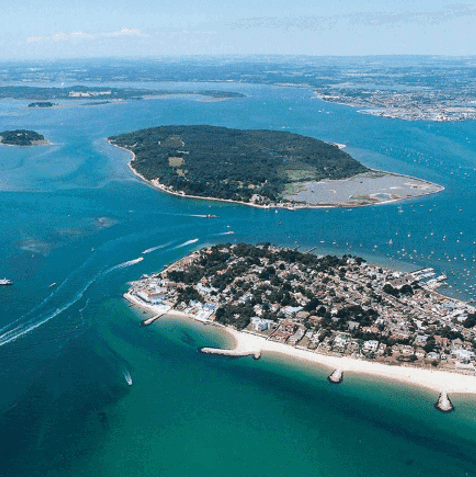 An aerial view of the coast with various islands and boats scattered in the striking blue water on a sunny day