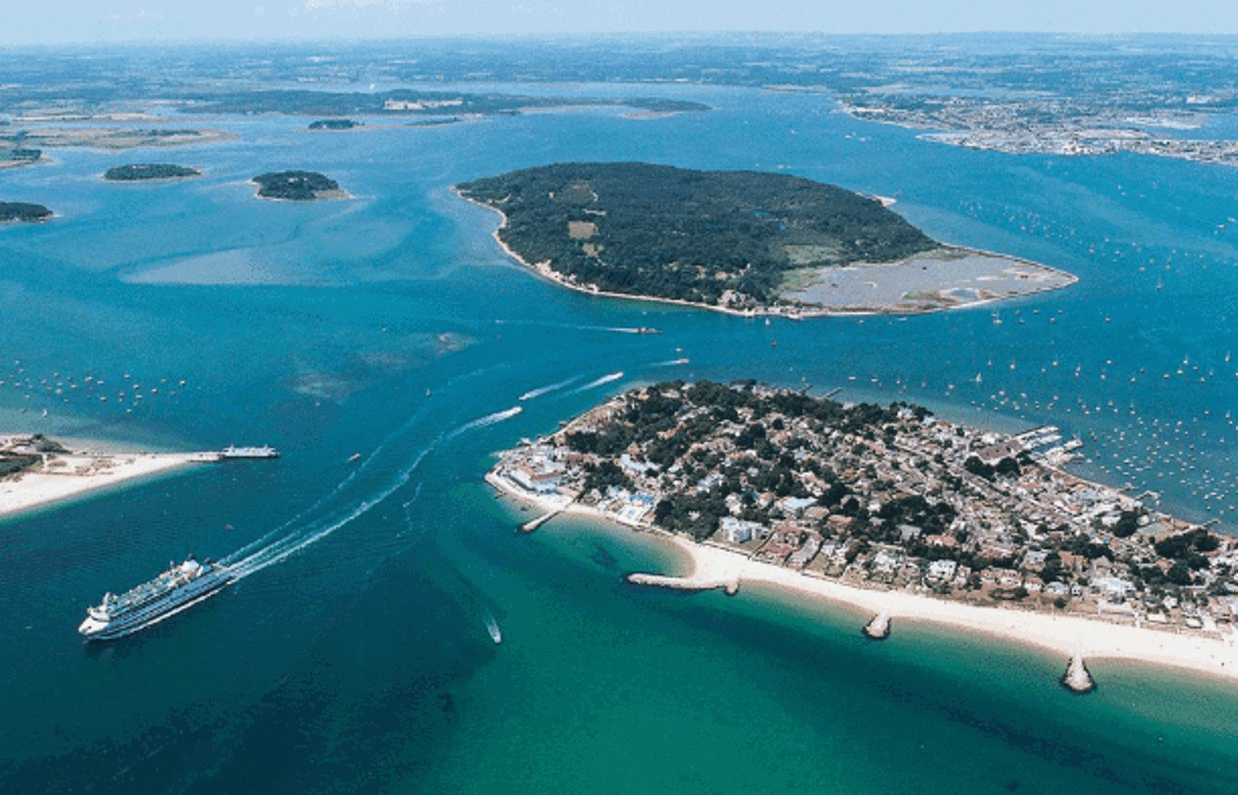 An aerial view of the coast with various islands and boats scattered in the striking blue water on a sunny day