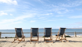 Deckchairs sat on the sand at Southside area overlooking the sea with blue skies