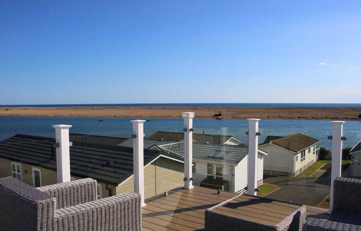 External of a caravan on pitch with skydeck, outdoor furniture and seaviews