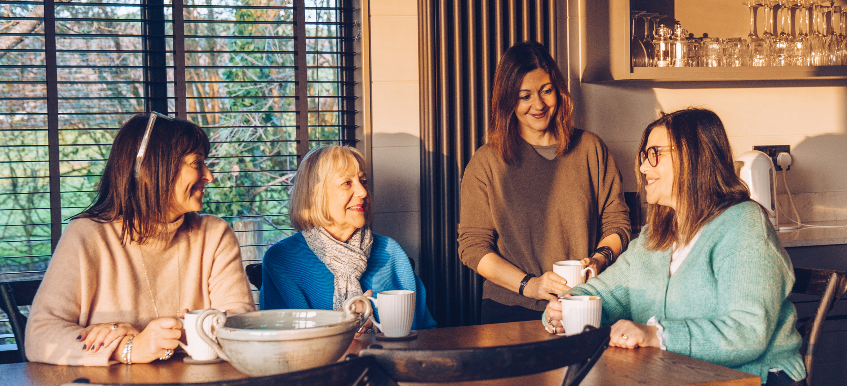 Family Owners of Waterside sat at a table in a lodge smiling at each other