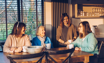 Family Owners of Waterside sat at a table in a lodge smiling at each other