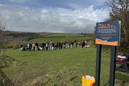 A group of people with dogs in a dog agility field for a Trufts Dog Show at Tregoad Holiday Park